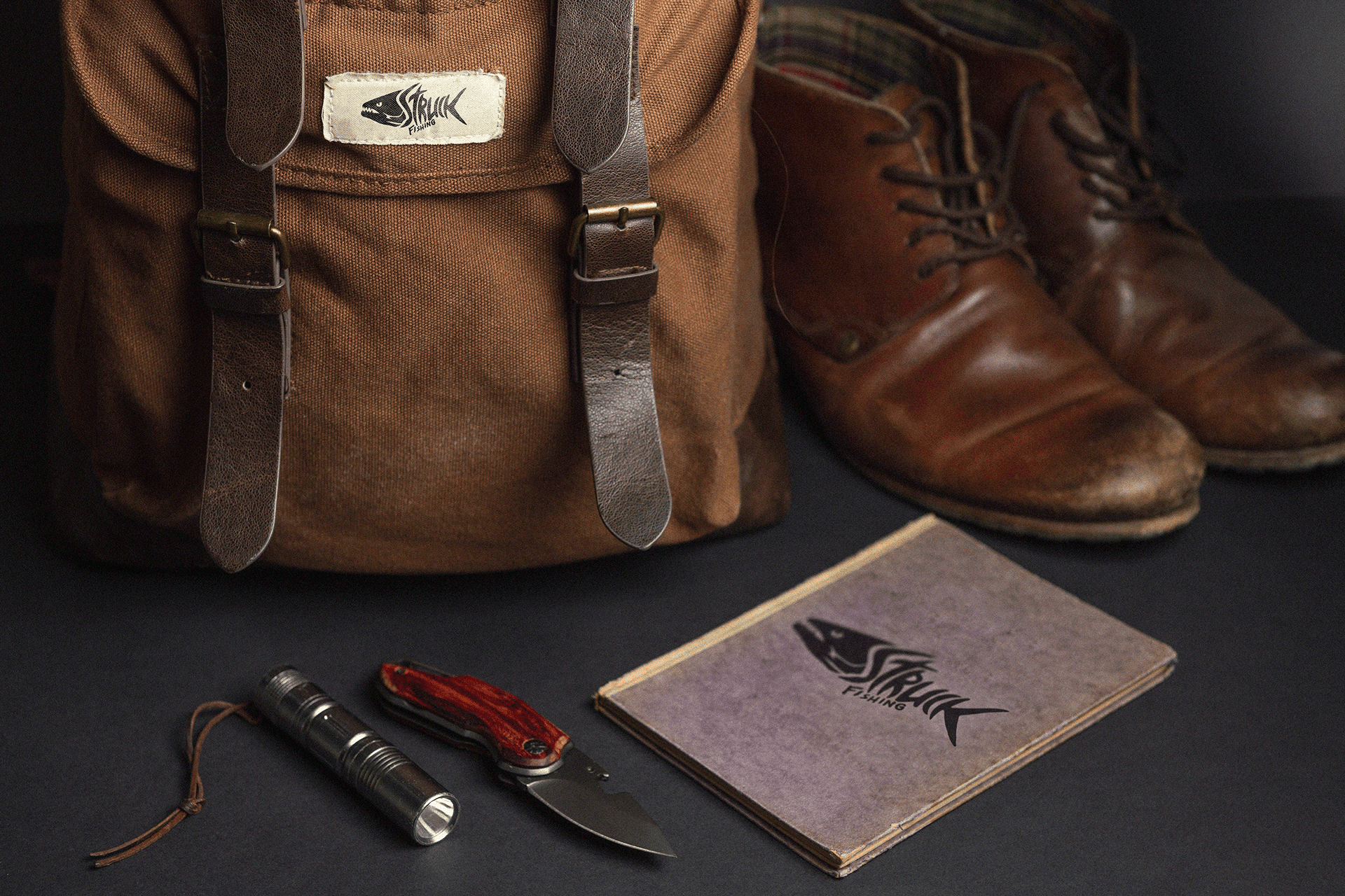 Produtos lifestyle da marca Struck Fishing: botas de couro, carteira e acessórios dispostos em composição fotográfica